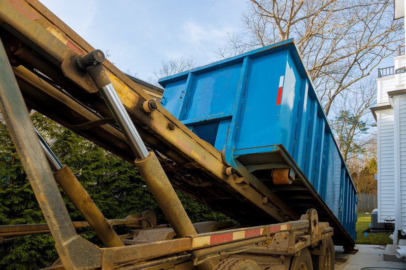 Blue dumpster being placed at a home in Kenosha.
